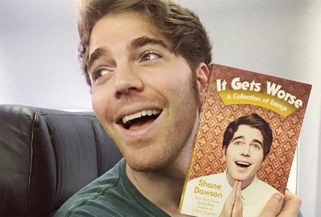 Shane taking a picture with his book "It Gets Worse".